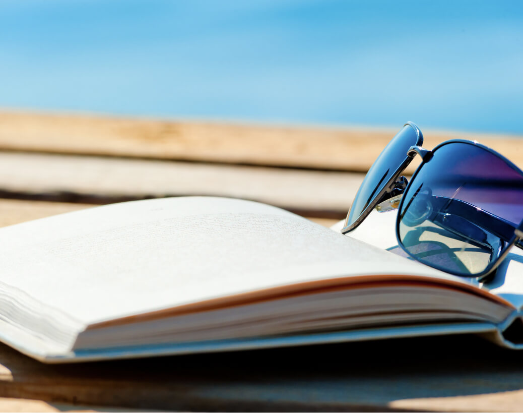 Open book and sunglasses sitting on a dock
